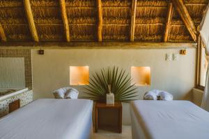 two beds in a room with two chairs and a table at Secret Garden Hideaway in Balcheil
