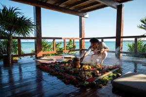 a man standing next to a table with a flower arrangement at Secret Garden Hideaway in Balcheil +14 photos