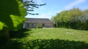 a small house in a yard with a grass field at Gîte La Buhennerie 2 personnes in Longues-sur-Mer