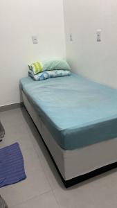a bed in a room with a blue mattress at Republica Fusinato in Itajaí