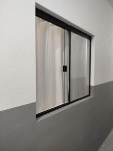 a window in a wall with a curtain at Republica Fusinato in Itajaí