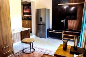 a kitchen with a stainless steel refrigerator and a stool at GT holiday home in Chobe