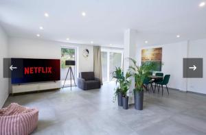 a living room with a tv and a table and chairs at Luxee Apartment in Friedrichshafen