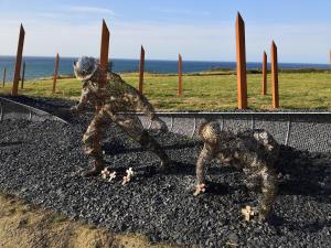 a metal statue of two men playing a game at Gîte Le Val de Marigny 2 personnes in Longues-sur-Mer +21 photos
