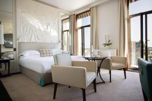 a bedroom with a bed and a table and chairs at Hotel Royal-Riviera in Saint-Jean-Cap-Ferrat