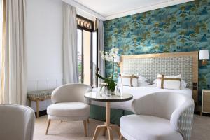 a bedroom with a bed with a floral wall at Hotel Royal-Riviera in Saint-Jean-Cap-Ferrat