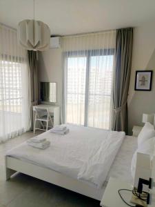 a bedroom with a large white bed with windows at Helena Resort & Spa in Kalecik +8 photos