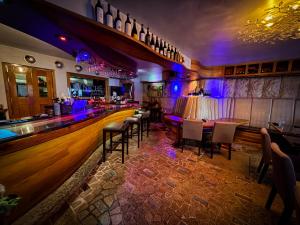 a bar with tables and chairs and purple lights at Acacia Boutique Hotel in San Juan