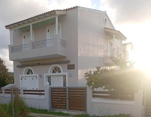 a white house with a fence in front of it at Villa Stefania in Acharavi
