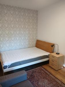 a small bedroom with a bed and a night stand at Biedronka- samodzielny apartament dla 3 osób z miejscem parkingowym in Sopot