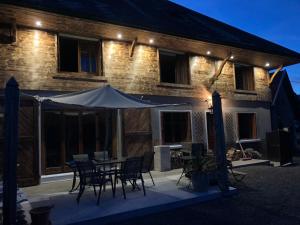 a house with a table and chairs in front of it at Gîte Les sources proche Annecy in Vaulx