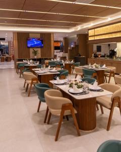 a dining room with tables and chairs and a tv at Atlantis Alger Aéroport ex Ibis in Alger