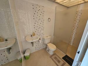 a bathroom with a toilet and a sink and a shower at PLAYABRISAMAR in San Antero +29 photos