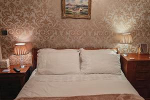 a bedroom with a bed with two night stands and two lamps at Drumhirk House in Newtownards