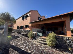 a building with a palm tree in front of it at Tropical Paradice Villa in Icod de los Vinos