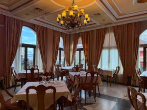 a dining room with tables and chairs and windows at Hotel Santa Teresa in Ávila +31 photos