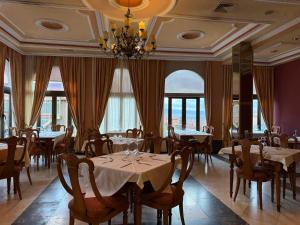 a dining room with tables and chairs and a chandelier at Hotel Santa Teresa in Ávila