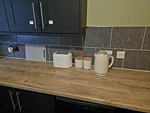 a kitchen counter with three toasters on top of it at Cog Lane House in Burnley +7 photos