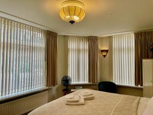 a bedroom with a bed and a lamp and windows at Bed and Breakfast Rotterdam in Rotterdam