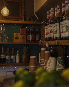 a kitchen with a shelf with bottles and cups at Riverside Cottage B&B in Lynmouth