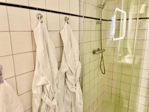 a bathroom with white towels hanging from a shower at Bed and Breakfast Rotterdam in Rotterdam