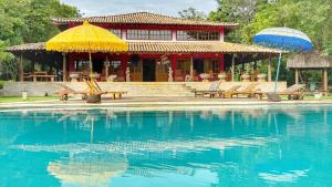 a house with a yellow umbrella and a swimming pool at Pousada Taman Baru in Pirenópolis