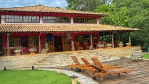 a group of chairs on a deck in front of a house at Pousada Taman Baru in Pirenópolis