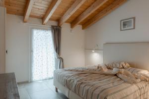 a bedroom with a bed and a large window at Ca' del Volo in Grezzana