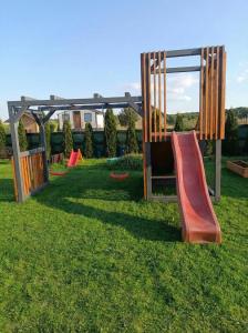 a playground with a slide in the grass at Cichosza Miłomłyn in Miłomłyn