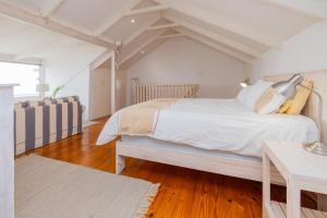 a bedroom with a large white bed and a table at Beachfront Bliss in Langstrand +17 photos
