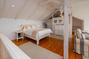 a white bedroom with a bed and a wooden floor at Beachfront Bliss in Langstrand