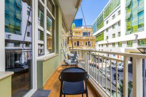 a balcony with a table and chairs in a building at Amel's Rooms by PikHost in Tirana