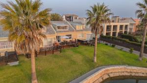 an aerial view of a house with palm trees at Beachfront Bliss in Langstrand