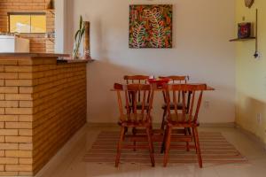 a table and two chairs at a kitchen counter at Casa Mohini Refúgio nas montanhas de Teresópolis Quarto com deck rede suspensa, lareira e cachoeira in Teresópolis