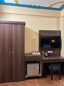 a room with a desk with a tv and a table at Himalayan Stayz in Rishīkesh