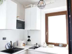 a kitchen with white cabinets and a sink and a window at Casa Nausicaa in Pergine Valsugana