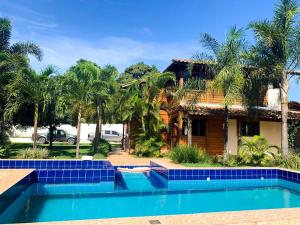 a house with a swimming pool in front of a house at Casa Guarapari in Guarapari