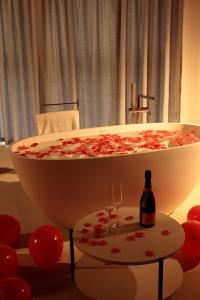 a bath tub with two glasses and a bottle of wine at Palazzo Simonetti in Ascoli Piceno