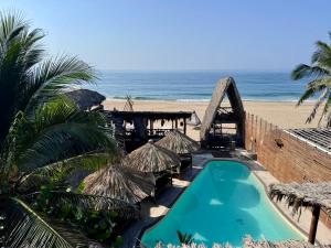 a resort with a swimming pool and the beach at baXar in Pie de la Cuesta