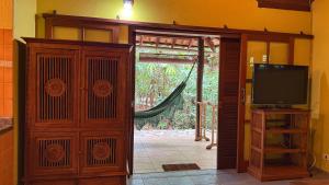 an open door to a room with a television and a door at Pousada Taman Baru in Pirenópolis