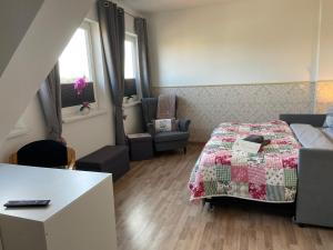 a bedroom with a bed and a chair and a table at Ferienzimmer 2 Engelmann-Beck in Hanstedt