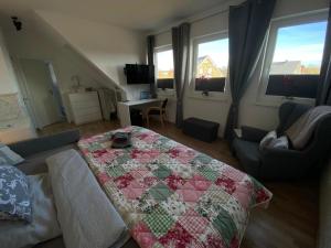 a living room with a bed with a quilt on it at Ferienzimmer 2 Engelmann-Beck in Hanstedt