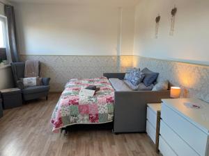 a bedroom with a bed and a couch in it at Ferienzimmer 2 Engelmann-Beck in Hanstedt