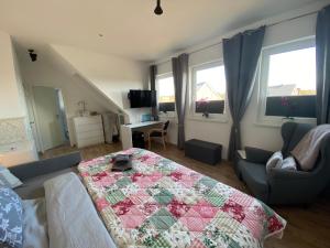 a living room with a quilt on a bed at Ferienzimmer 2 Engelmann-Beck in Hanstedt +12 photos