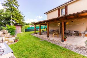 a patio with chairs and tables in a yard at house Al Cascinale in San Severino Marche