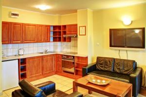 a kitchen with a couch and a table in a room at Apartamenty & Restauracja Janus in Ełk