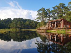 a cabin on the shore of a lake at Gluba Lavvo in Harkmark