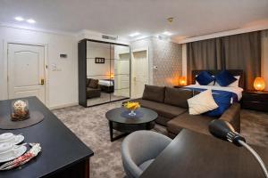 a living room with a couch and a bed at Al Basem Hotel in Amman