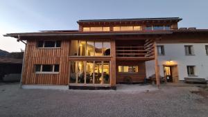 a large wooden house with glass windows in front of it at Doppelzimmer in Boutique Hostel in Pfronten