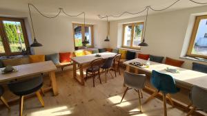 a dining room with tables and chairs and windows at Doppelzimmer in Boutique Hostel in Pfronten